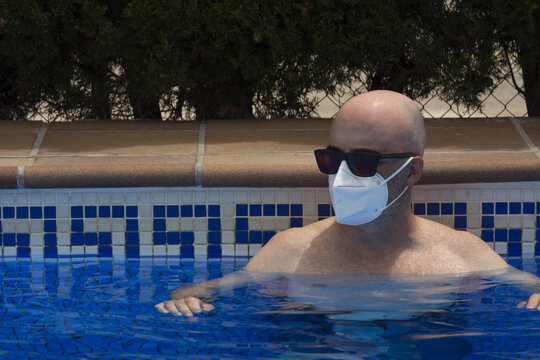 Man with medical mask in a swimming pool
