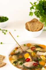 Chicken soup with fresh vegetables, chicken wings broth and young potatoes with onions and carrots, chopped green onions and parsley