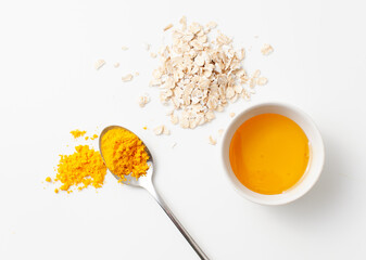 Recipe rejuvenating homemade face mask made of turmeric, honey and oatmeal on a white background.