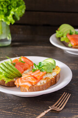 Different delicious sandwiches for breakfast, bread with cheese, avocado and trout, sandwich with egg and parsley