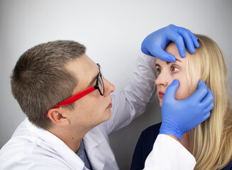 An ophthalmologist examines a woman who complains of a burning sensation and pain in her eyes. Eye...