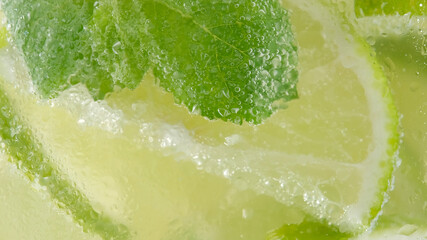 juicy sliced lime and mint leaf top view