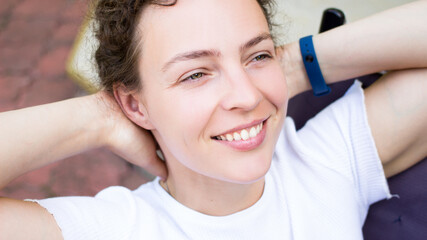 Portrait of happy peaceful young woman holding hands behind head,stretching arms,looking aside,dreaming about vacation.Smiling caucasian girl lean on chair,enjoying relaxing break during working day