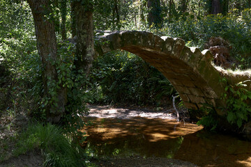 Pequeño puente antiguo sobre un río con poca agua