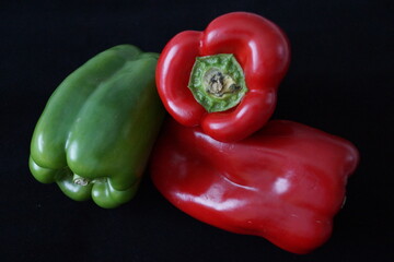 Pimiento rojo y verde sobre fondo negro