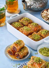 Baklava, Middle eastern different delights, dried dates, pistachios, honey, mint tea on a light blue background. Ramadan.