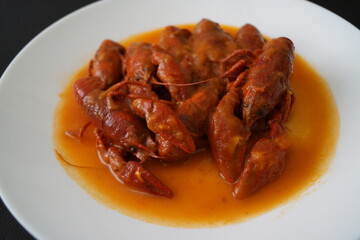 Cangrejos de río en salsa de tomate, con cebolla y pimiento rojo y verde