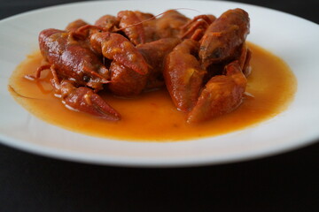 Cangrejos de río en salsa de tomate, con cebolla y pimiento rojo y verde