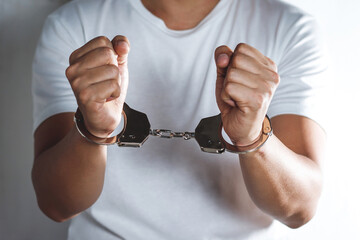 Prisoner man with handcuffs in his arms