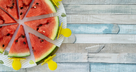 Flat lay of watermelon triangular slices on sticks. Fresh fruit popsicles summer refreshing cooling