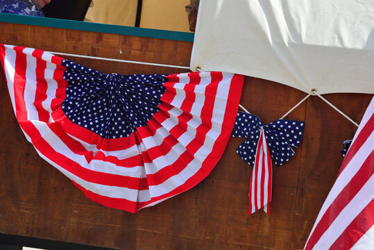 Banner and ribbon with American flag design on the side of a wagon.