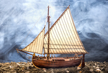 model of old wooden sailing ship with more fog on the background