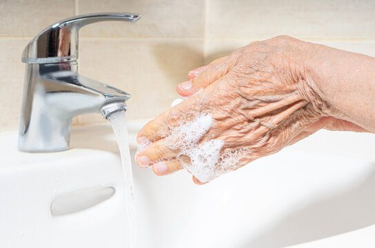 Elderly woman hands washing. Hand hygiene to prevent infection. Take care of the elderly.