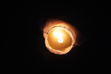 A sky lantern flying in the dark sky