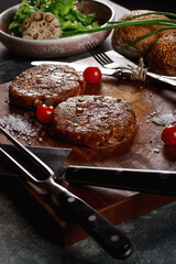 Raw Ground beef meat Burger steak cutlets with ingredients on the board.
