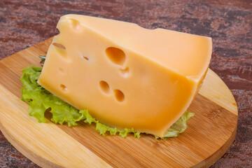 Maasdam cheese  in the board served salad leaves