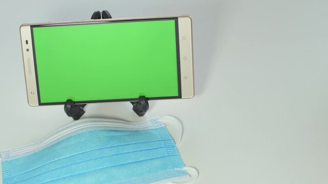 Mobile with green screen, online purchase of protective mask and alcohol gel, payment by credit card.