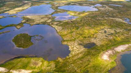 Landscape of the forest-tundra, aerial view, traces of caterpillar equipment on the surface of tundra vegetation, nature conservation, environmental problems of the tundra.
