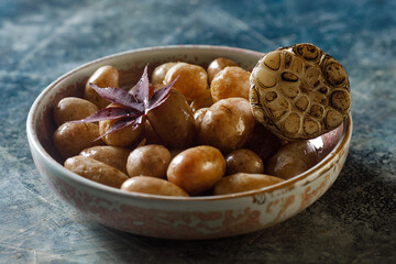 Boiled young potatoes with oil and roasted garlic, in a wooden dish.