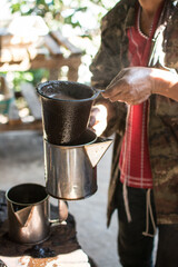 Fototapeta na wymiar Coffee grinder and boiling water to brew coffee of the hill tribe people at Doi Inthanon National Park, Thailand