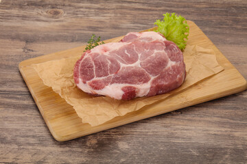 Raw pork steak over wooden board
