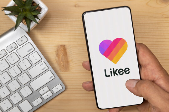Lutsk, Ukraine - July 17, 2020: Hand Holding and tapping smartphone with Likee Logo on it with according text.