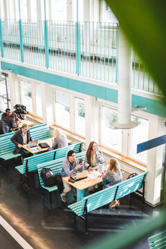High angle view of male and female students at cafeteria in university