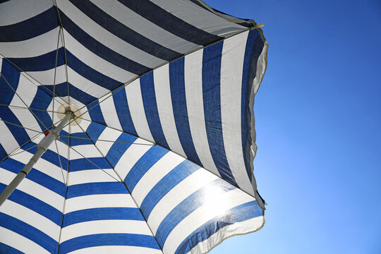 debajo de la sombrilla de rayas azul y blanca protegerse del sol 4M0A9402-as20