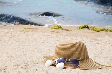 Fototapeta na wymiar hat, sunglasses and shells on the beach, summer vacation concept