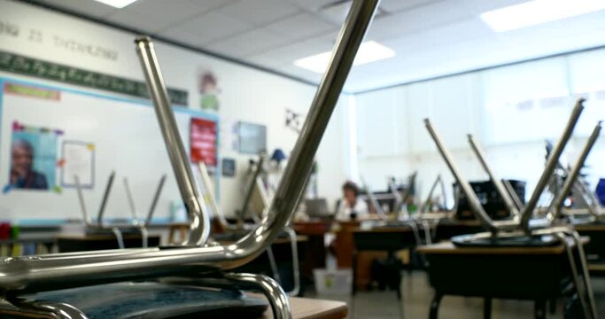 elementary school teacher works in empty classroom