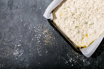 Raw focaccia dough in a baking dish