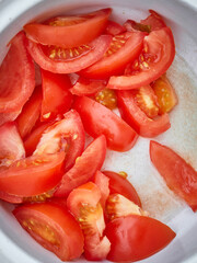 Sliced tomato in a white plate. Fresh vegetables, healthy food