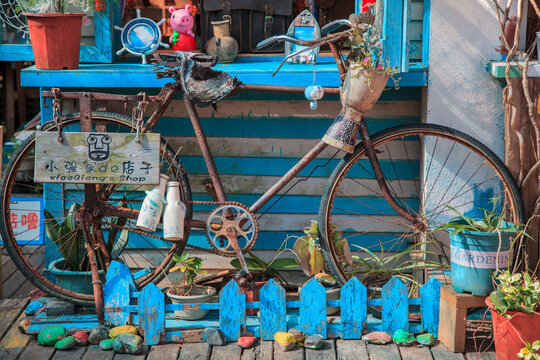 China, Hainan Island - December 1, 2018: Yalong Bay Tropical Paradise Forest Park, Shop decoration, old bike and various items, editorial.
