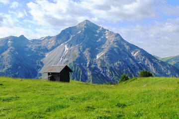 Fototapeta na wymiar Hütte vor Berggipfel in den Alpen
