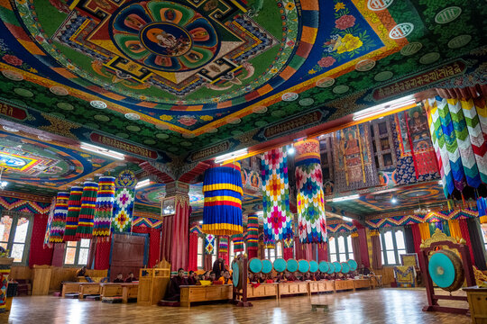 Buddhist monks worship with round gongs inside a prayer room at a monastery, Bhutan - Powered by Adobe