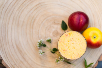 Creative Flat Lay Top View of Fresh Fruit Smoothie Drink Bubbles in Glass, Mint Herb Leaves and Apple and Nectarine on Wooden Background, Copy Space. Healthy Diet.