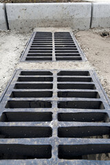 New rainwater grate on the road or sidewalk, installation in concrete. City sewage system for draining water during heavy rain