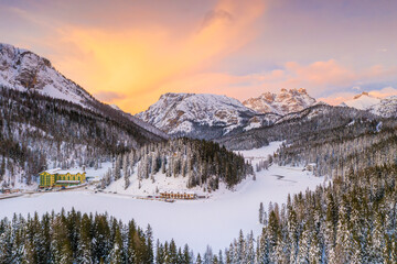 View by drone of sunset over Monte Piana and woods covered with snow, Misurina, Dolomites, Belluno province