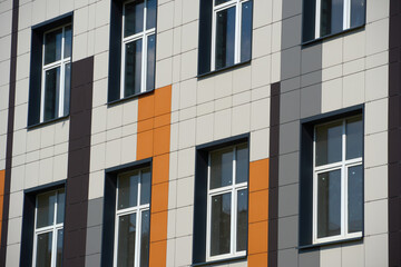 facade of a modern building on a bright Sunny day, siding and Windows, beautiful exterior of the new building