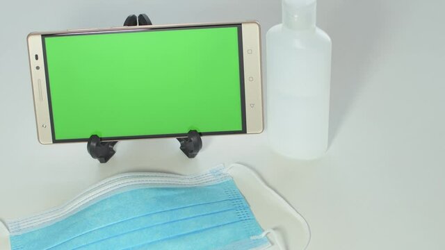 Mobile with green screen, online purchase of protective mask and alcohol gel, payment by credit card.