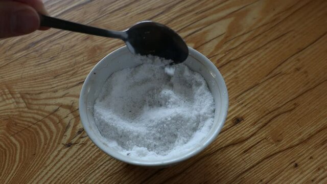 Mixing salt in little bowl with spoon. Spices and ingredients