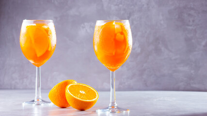 Aperol spritz cocktail on a gray background. Two glasses of aperol spritz with orange slised....