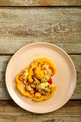 Vegetable stew on a beige plate on a wooden table.Copy space.