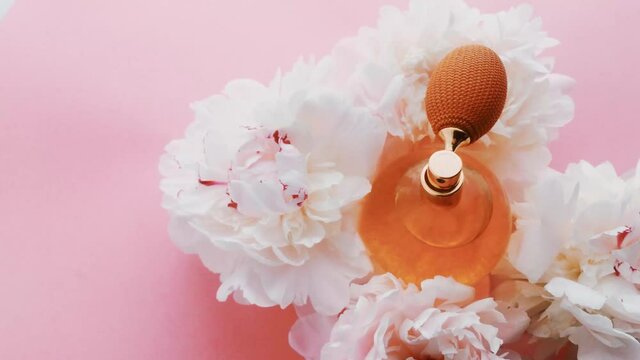 Citrus perfume bottle with peony flowers, chic fragrance scent as luxury cosmetic, fashion and beauty product background, stock footage