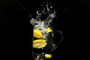 lemon slices falling into water on black background - water splash - high speed photography