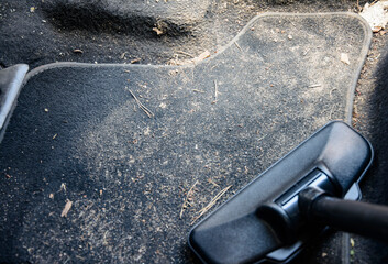Cleaning dirt in a car with a vacuum cleaner.