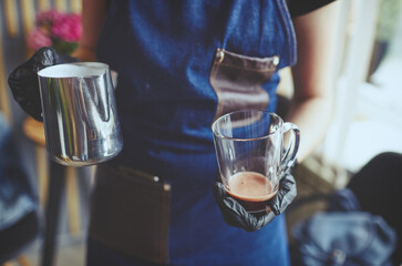 Barista making pink matcha latte with milk. Bartender preparing tasty drink.Blurred image,selective focus