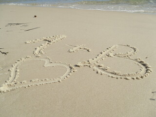 heart and letters on sand