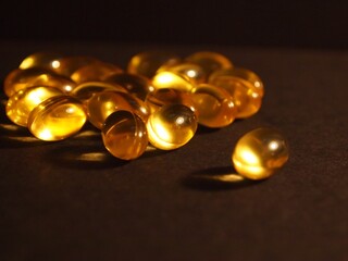 Trans-lucid cod liver oil pills under colourful light
