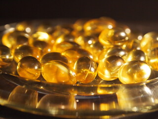Trans-lucid cod liver oil pills under colourful light
